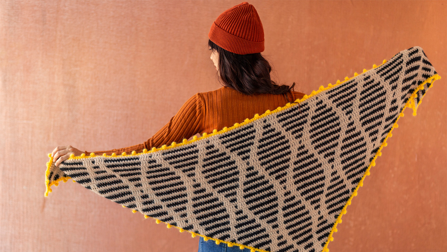 woman holding crochet item behind her back